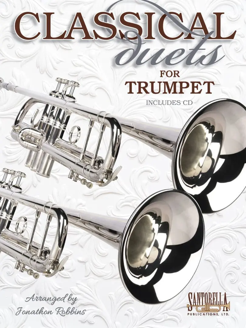 A pair of silver trumpets sitting on top of a sheet.